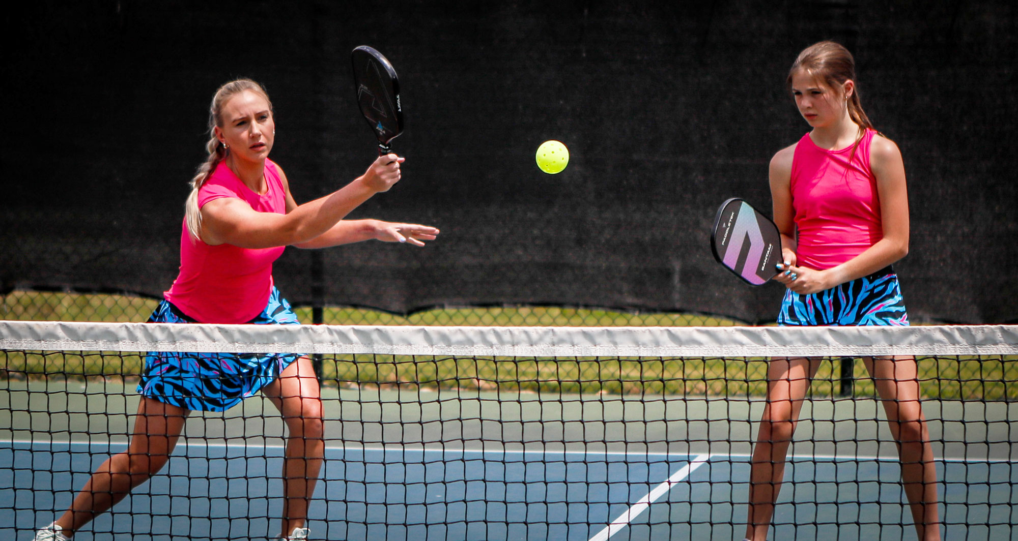 Two women playing pickleball wearing Faye + Florie outfits.